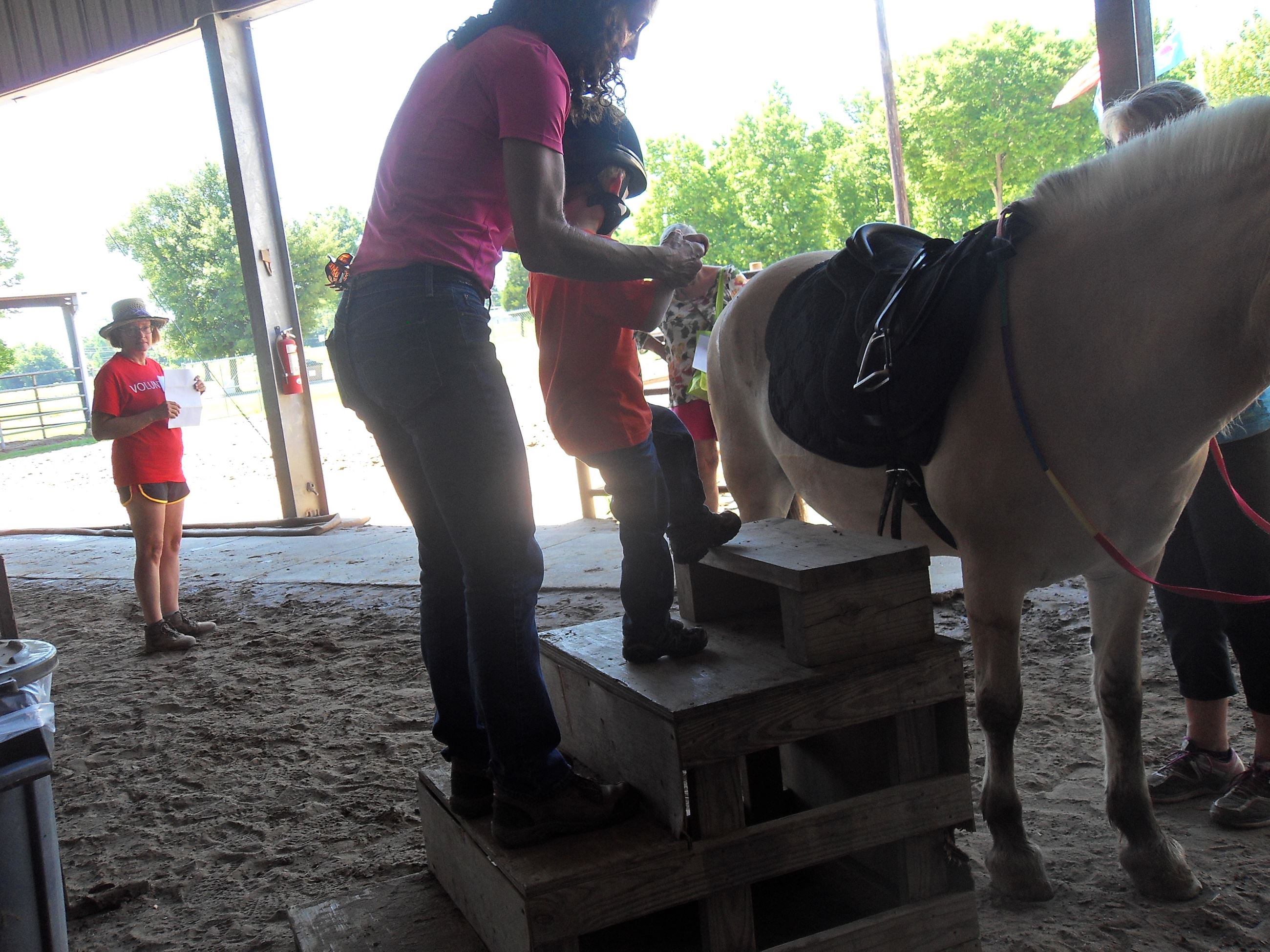 Little kid climbing onto a horse